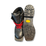 Black Alico women's ski boots with red laces and a lugged outsole, shown from the front with the sole facing upwards against a white background.