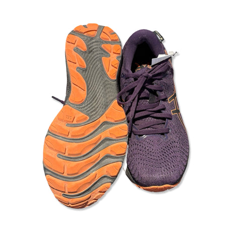 Lila Asics Gel-Cumulus 24 GTX löparskor för dam, en sedd uppifrån och en som visar den orangea sulan.