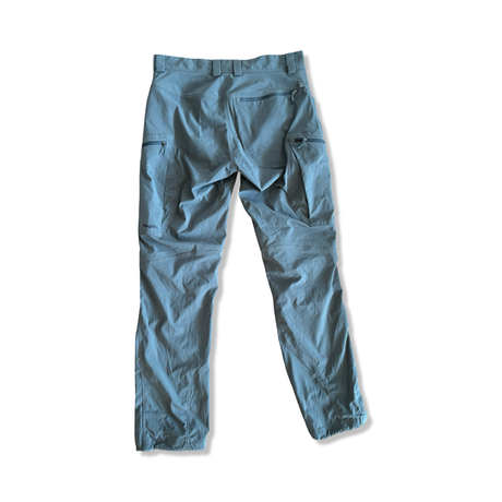 Grey Haglöfs Mid Treek men's hiking pants, back view with detailed zip pockets against a white background.