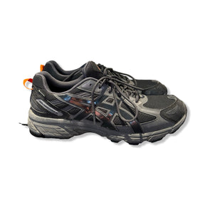 Asics GEL-Venture 6 Gore-Tex träningsskor i svart med orangea detaljer, fotograferade från sidan mot vit bakgrund.