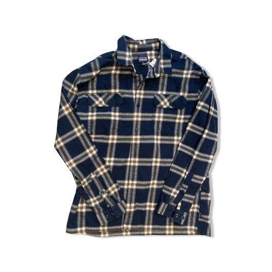 Patagonia Fjord Flannel Shirt för herr i marinblått och beige rutmönster, fotograferad platt mot en vit bakgrund.