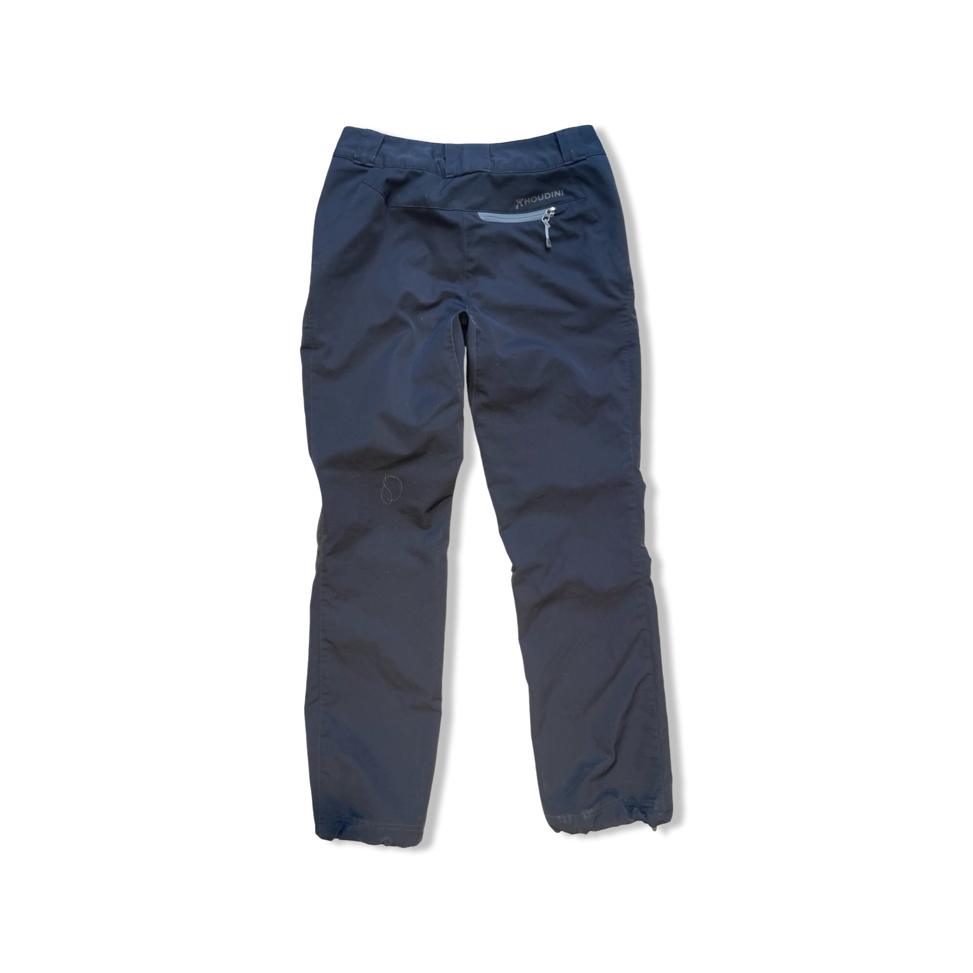 Baksidan av Houdini Motion Pants softshellbyxor för dam i svart, fotograferade mot en vit bakgrund.