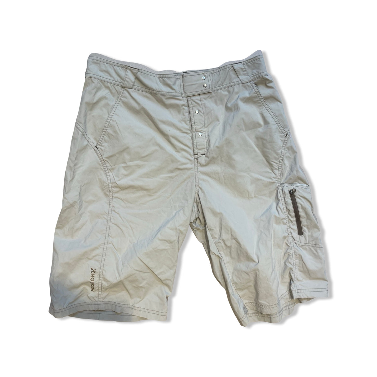 Beige Houdini funktionsshorts för dam, fotograferade platt mot en vit bakgrund.