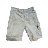 Beige Houdini funktionsshorts för dam, fotograferade platt mot en vit bakgrund.