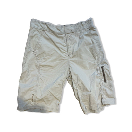 Beige Houdini funktionsshorts för dam, fotograferade platt mot en vit bakgrund.