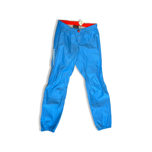 Blå Peak Performance Stark Pant Gore-Tex skalbyxa för dam, fotograferad framifrån mot en vit bakgrund.
