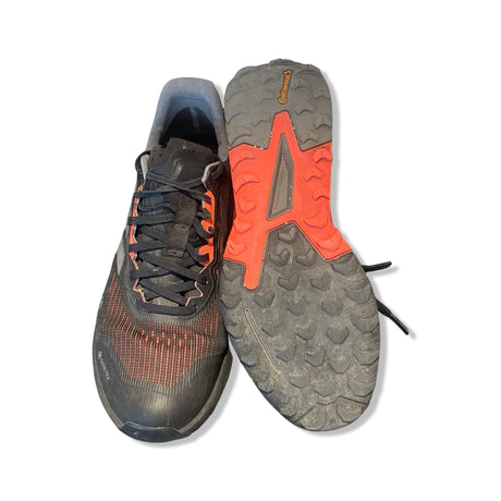 Adidas Terrex Gore-Tex löparskor för dam i svart och orange. En sko framifrån och en som visar sulan mot vit bakgrund.