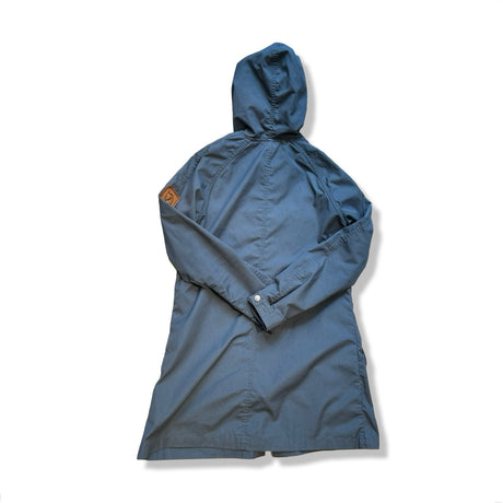 Baksidan av en blå Fjällräven Greenland Parka Light för dam med huva, fotograferad mot en vit bakgrund.