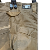Närbild på midjan och bakfickorna på ett par khaki skidbyxor för dam från Scott, visade mot en vit bakgrund.