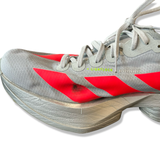 Grå löparskor Adidas Adizero Adios Pro 4 för dam med en fläck på ovandelen mot vit bakgrund.