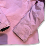 Close-up of the sleeve on the pink Peak Performance ski jacket with visible stains against a white background.