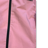 Close-up of a pink kids' Peak Performance ski jacket with a black zipper, showing the material's condition.