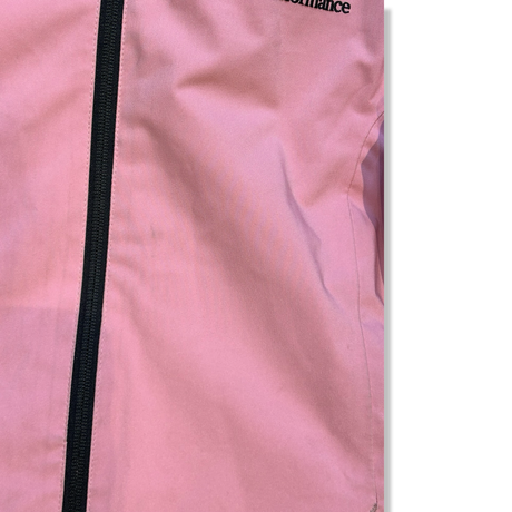 Närbild på en rosa skidjacka från Peak Performance för barn med svart dragkedja, som visar materialets skick.