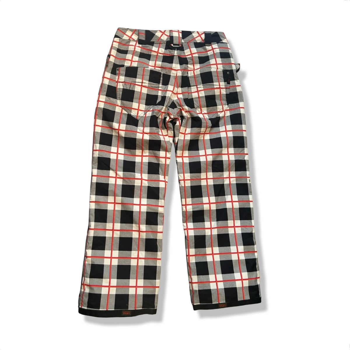 Back view of a red, black, and white plaid Vans women's ski pants against a white background.