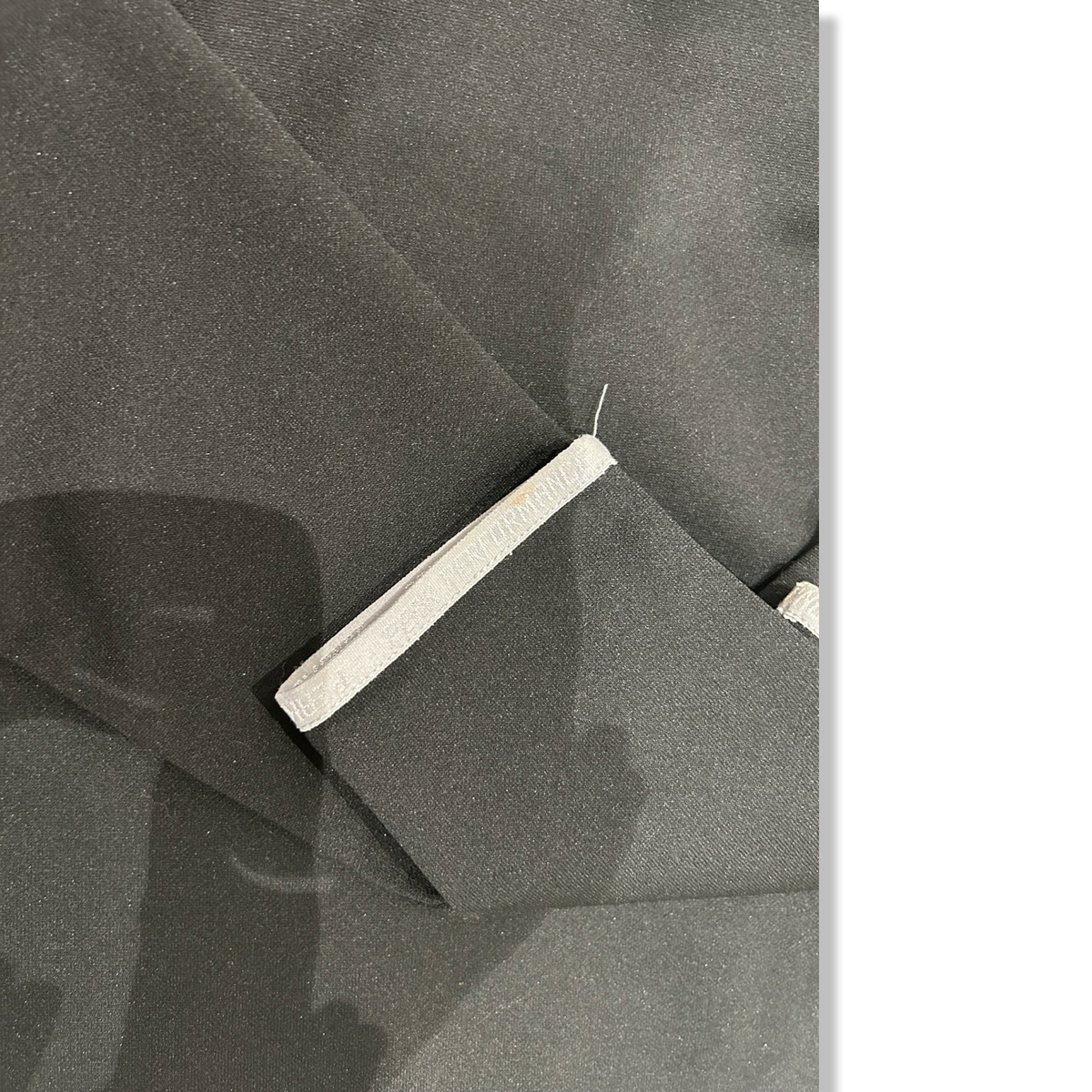 Close-up of the sleeve and minor stain on the black Peak Performance training shirt.