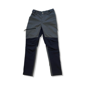 Grå och svarta Haglöfs Rugged Pant funktionsbyxor för barn, fotograferade framifrån mot en vit bakgrund.