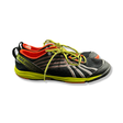 Black Merrell women's training shoes with yellow details, side view against a white background.