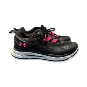 Black Under Armour HOVR women's running shoes with pink accents and white soles, side view against a white background.