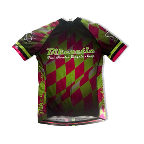 Grön och rosa mönstrad Jakroo cykeltröja för dam med texten Bikenetic, fotograferad framifrån mot vit bakgrund.