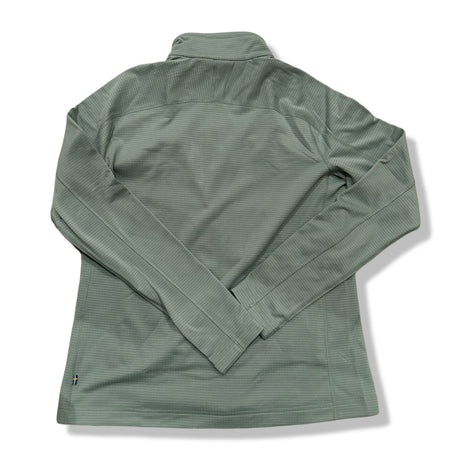 Baksidan av en grön Fjällräven Abisko Lite Fleece fleecetröja för dam, fotograferad mot vit bakgrund.