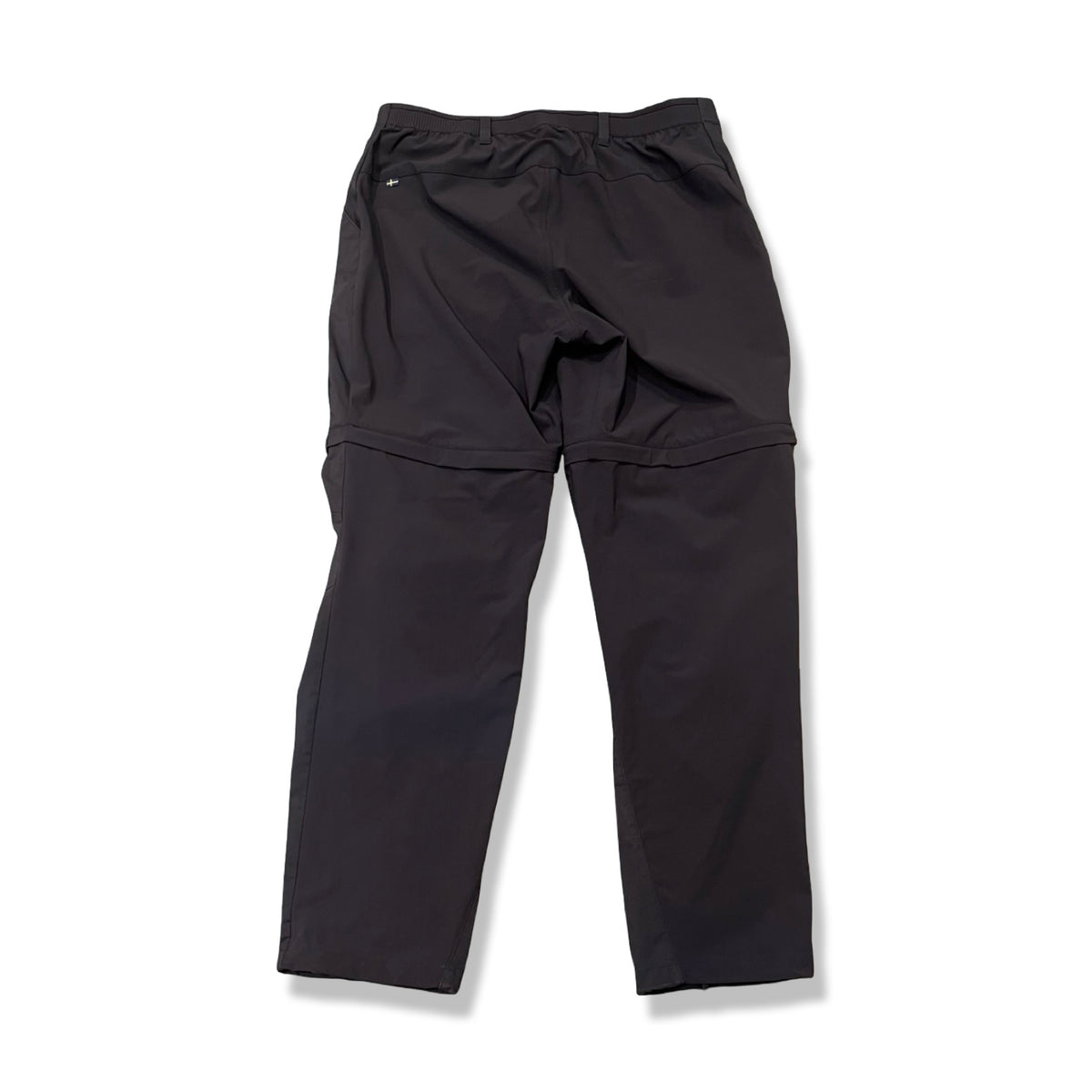 Back view of a pair of dark blue Fjällräven Abisko Hybrid Trail Trousers for women against a white background.