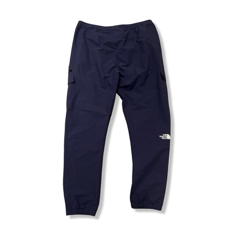 Baksidan av ett par blå funktionsbyxor från The North Face för herr, fotograferade mot en vit bakgrund.
