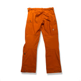 Back view of a pair of orange Re-Adventure women's hiking pants against a white background.