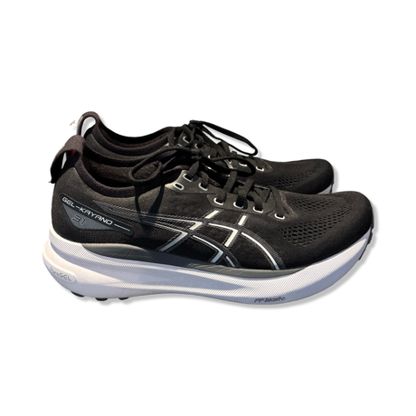Svarta löparskor Asics Gel-Kayano 31 med vit sula och logotyp, fotograferade från sidan mot en vit bakgrund.