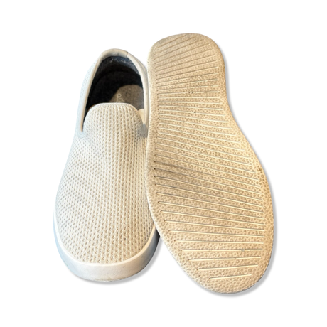 Allbirds Tree Loungers i vit stickad textil, där ena skon visar ovansidan och den andra visar sulan.