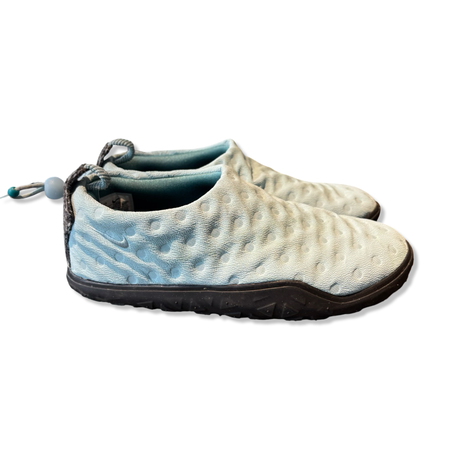 Ljusblå Nike ACG Air Moc unisex-sandaler med quiltad textur och svart sula, sedda från sidan mot vit bakgrund.