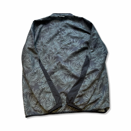 Patterned And Wander training jacket in grey-green with black details, back view against a white background.