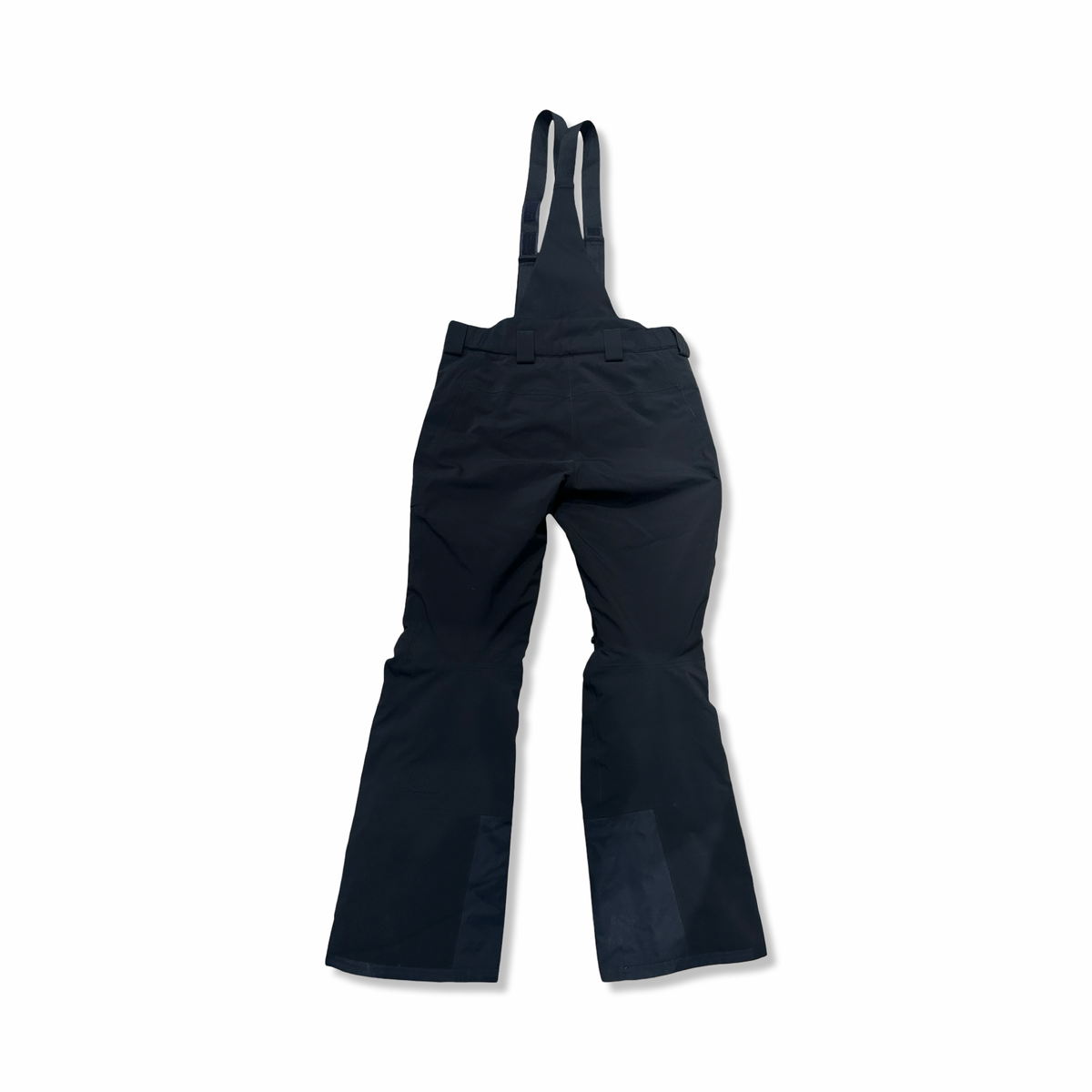 Back view of a dark blue The North Face men's ski pants with suspenders against a white background.