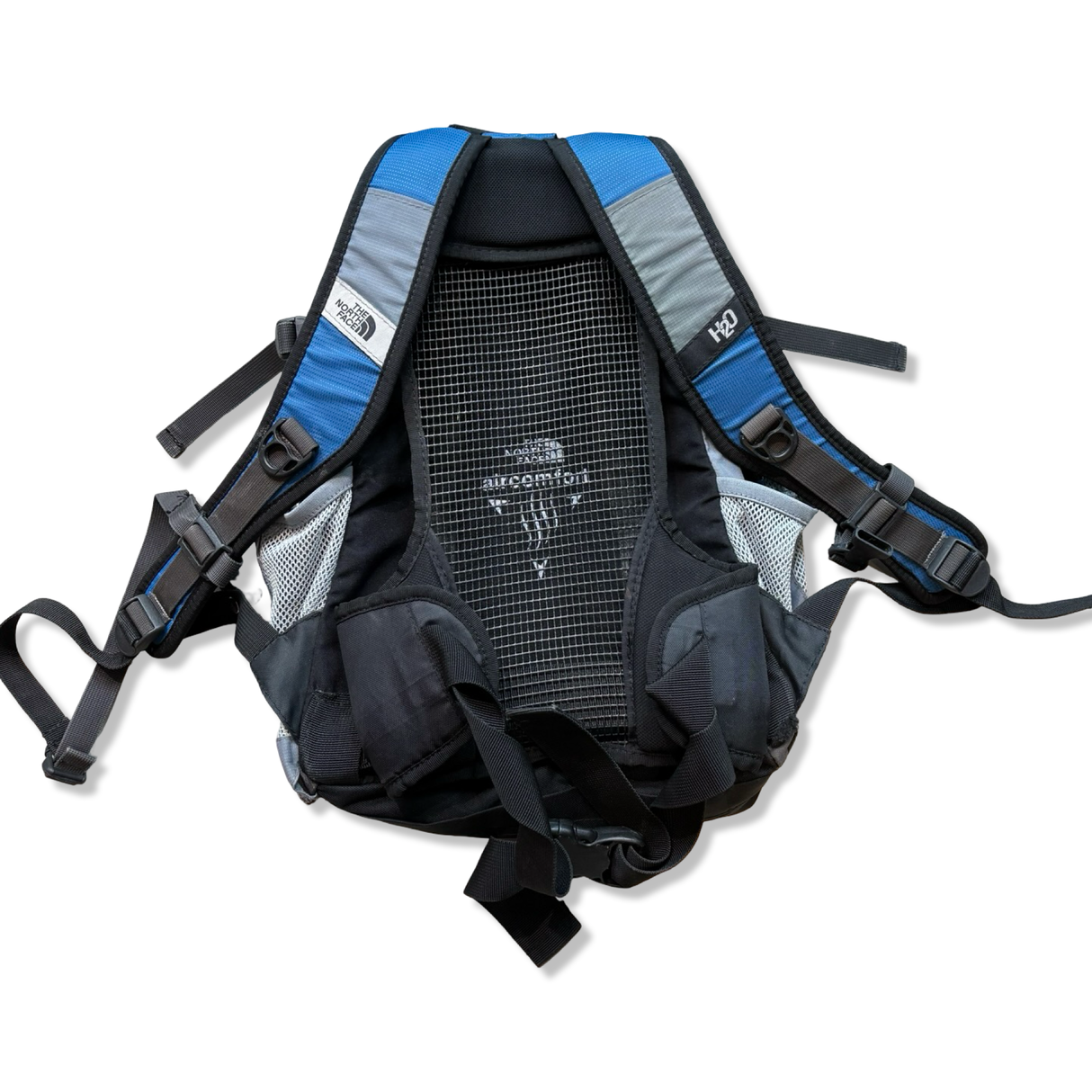 Blue and grey The North Face backpack with a breathable mesh back, back view against a white background.
