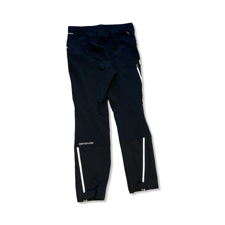 Black Ortovox hiking pants with white zippers and logo, back view against a white background.