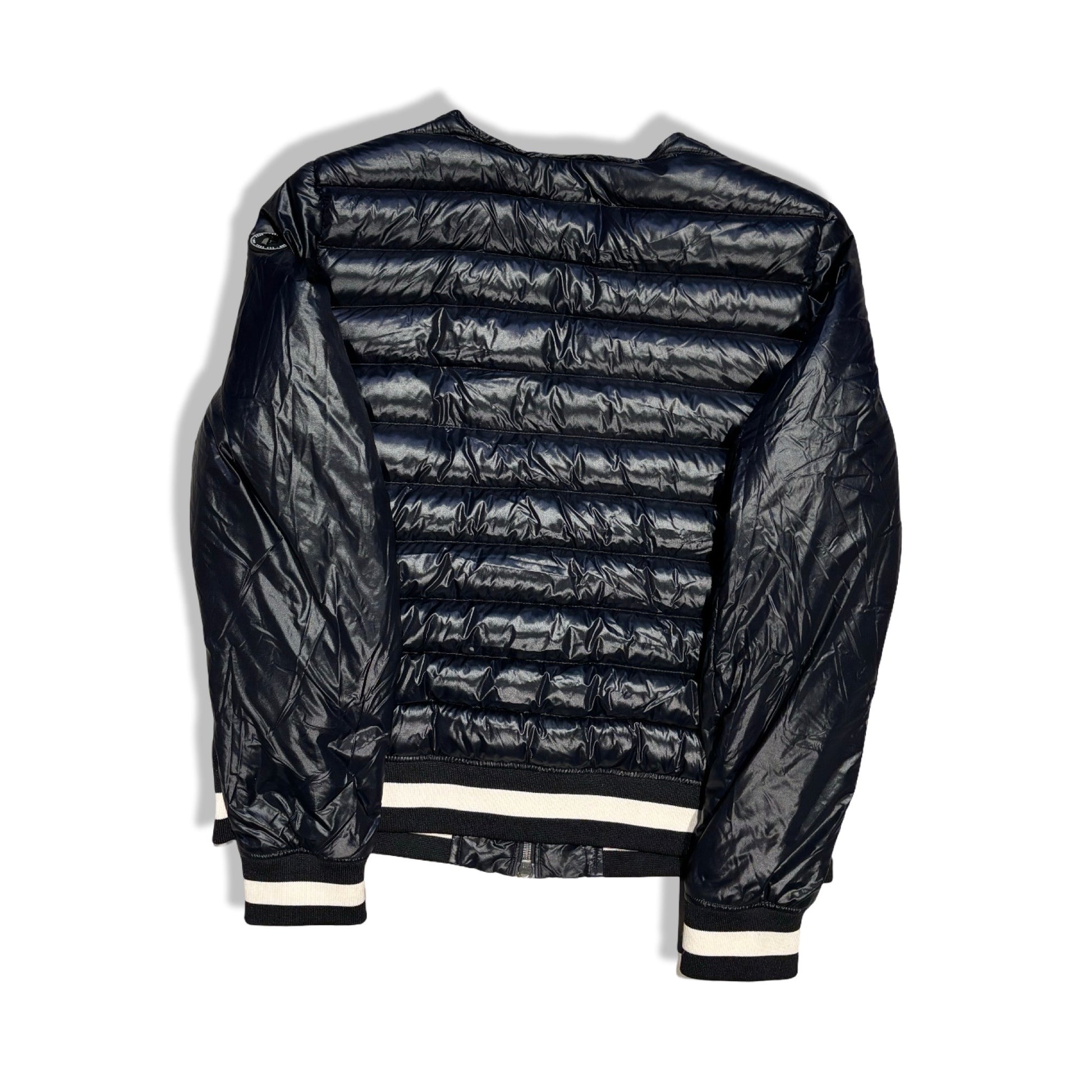 Baksidan av en svart, glansig dunjacka i bombermodell från Peak Performance för dam. Jackan har vita ränder på muddarna och är fotograferad mot en vit bakgrund.