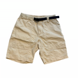 Cremevita ripstop-shorts från Peak Performance för herr med inbyggt svart bälte på vit bakgrund.