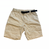 Cremevita ripstop-shorts från Peak Performance för herr med inbyggt svart bälte på vit bakgrund.