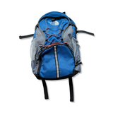 Blue The North Face backpack with grey details and mesh pockets, front view against a white background.