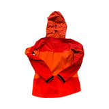 Orange Haglöfs Spinx skaljacka för dam i Gore-Tex, sedd bakifrån mot vit bakgrund.