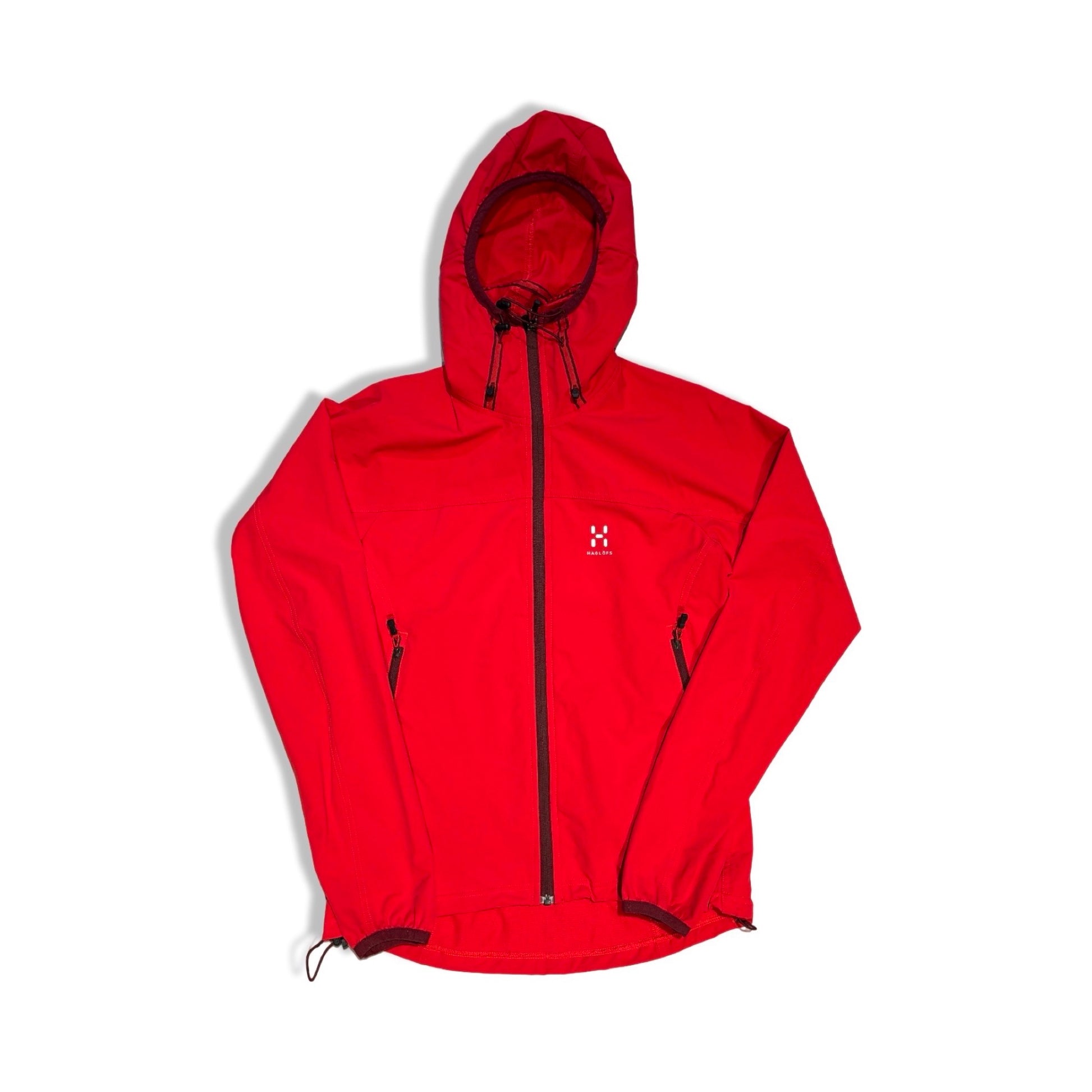 Haglöfs softshelljacka för dam i rött. Jackan har huva och heldragen dragkedja och är fotograferad platt mot en vit bakgrund.