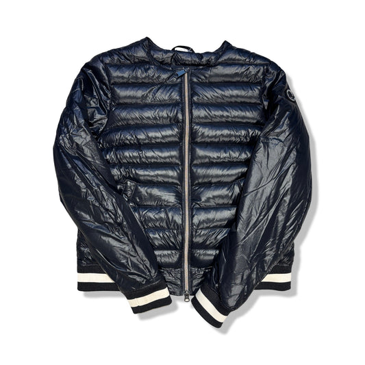 Svart, glansig dunjacka från Peak Performance för dam med randiga muddar, fotograferad framifrån mot en vit bakgrund.