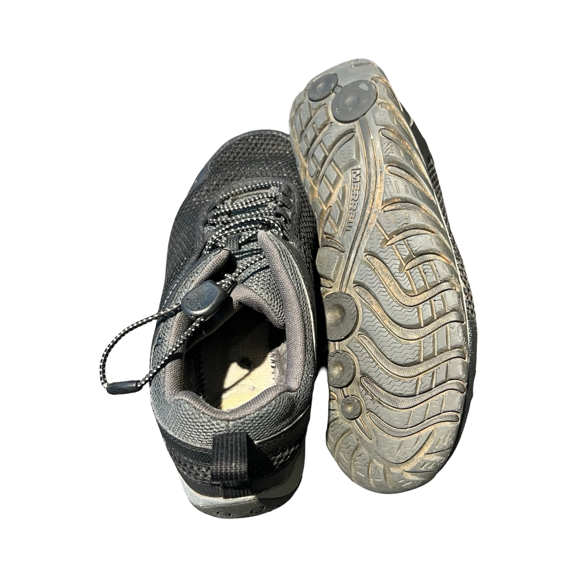 Ett par Merrell träningsskor för herr i svart och grått. En sko visar sulan och den andra visar ovansidan med snabbsnörning, fotograferade mot en vit bakgrund.