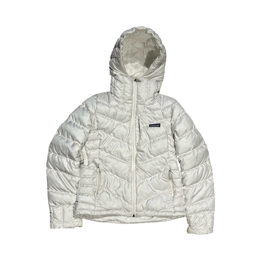 Patagonia dunjacka för dam i vitt. Jackan har huva och heldragen dragkedja och är fotograferad platt mot en vit bakgrund.