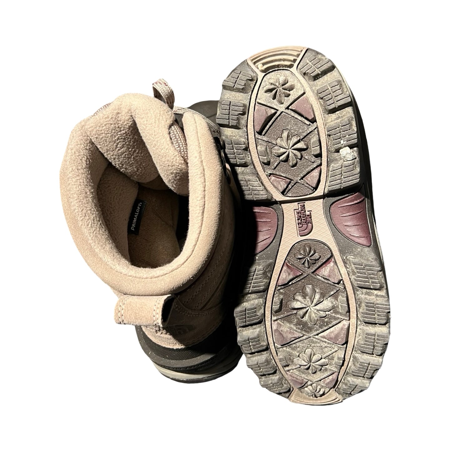 Undersidan och fodret på ett par bruna vinterkängor från The North Face för dam, fotograferade ovanifrån mot en vit bakgrund.