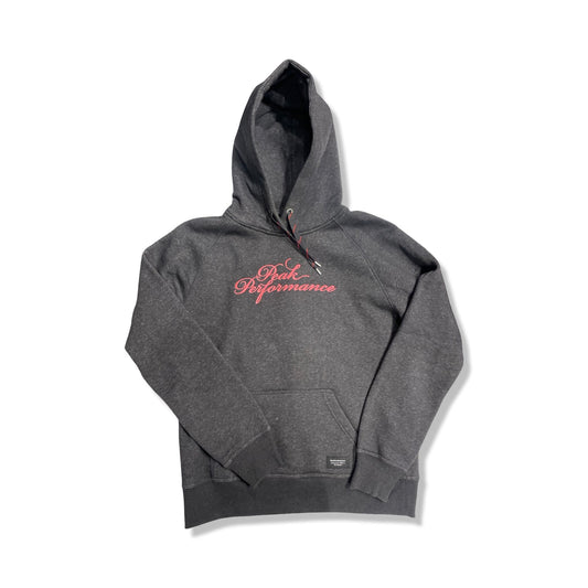 Peak Performance fleecehoodie för dam i mörkgrått. Hoodien har en rosa logotyp på bröstet och är fotograferad platt framifrån mot en vit bakgrund.