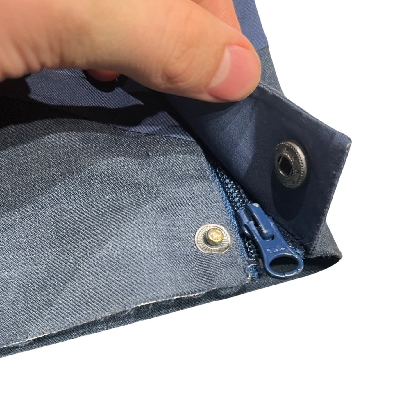 Närbild på den trasiga tryckknappen vid benslutet på de blå Kari Traa Voss Line Backflip skalbyxorna för dam.