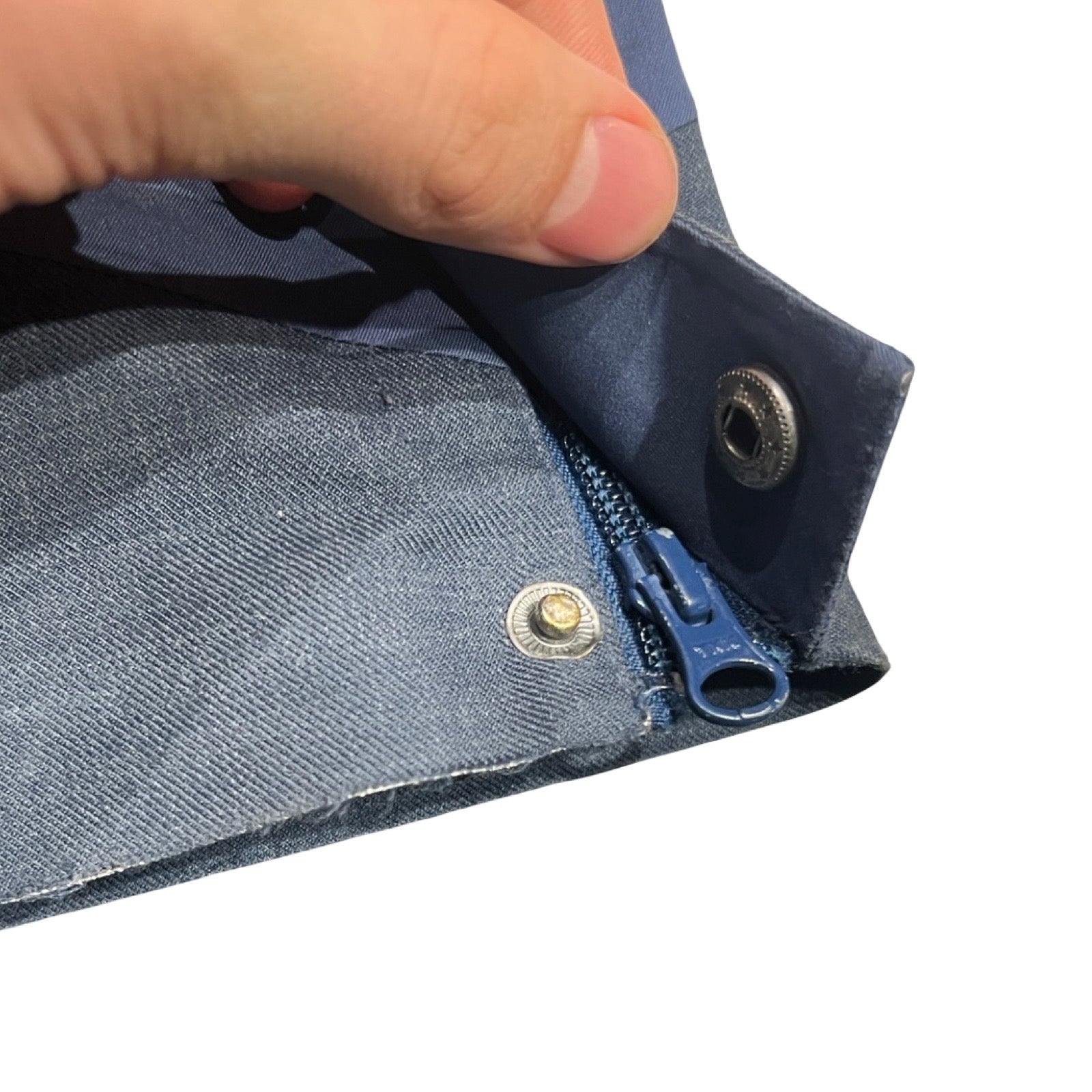 Närbild på den trasiga tryckknappen vid benslutet på de blå Kari Traa Voss Line Backflip skalbyxorna för dam.