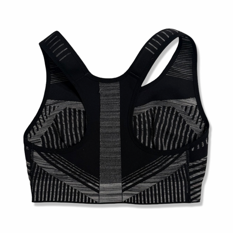 Baksidan av Nike Flyknit sport-BH för dam i svart och vitt, fotograferad mot en vit bakgrund.