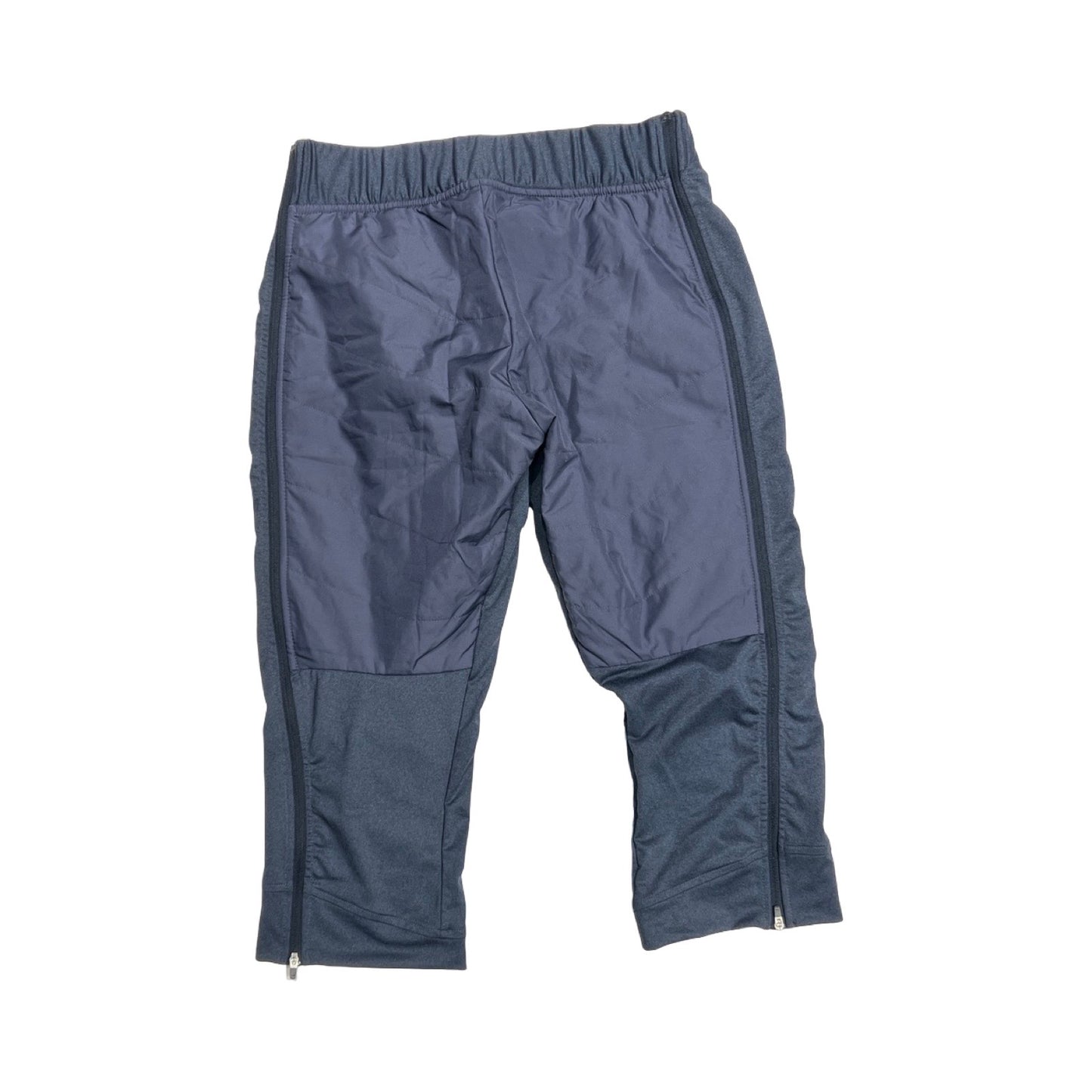 Baksidan av Bergans Stranda Hybrid 3/4 funktionsbyxa för dam i blått, fotograferade platt mot en vit bakgrund.