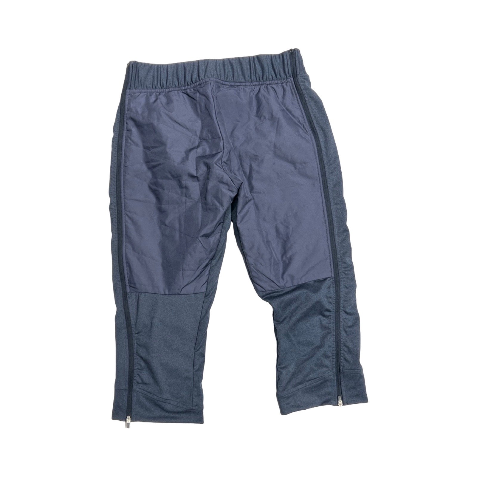 Baksidan av Bergans Stranda Hybrid 3/4 funktionsbyxa för dam i blått, fotograferade platt mot en vit bakgrund.